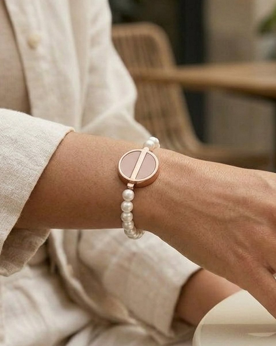The Beaded worn on the wrist: a strand of pearls and stone with the Charm as its centerpiece